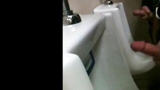 two slim dicks getting wanked at the urinals