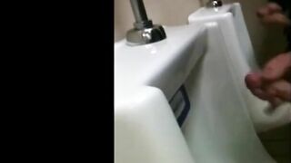 two slim dicks getting wanked at the urinals