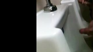 two slim dicks getting wanked at the urinals