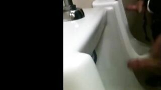 two slim dicks getting wanked at the urinals